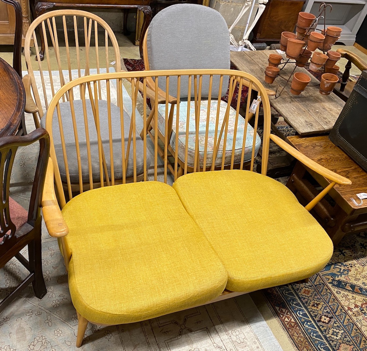 A mid century Ercol light beech three piece lounge suite, lacks three back cushions, settee length 133cm, depth 76cm, height 78cm